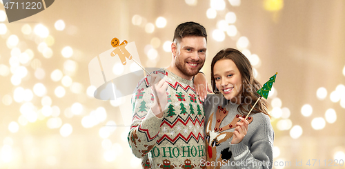 Image of couple with christmas party props in ugly sweaters