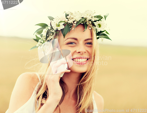 Image of happy young woman calling on smartphone at country