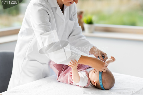 Image of pediatrician doctor measuring bab\'s head at clinic