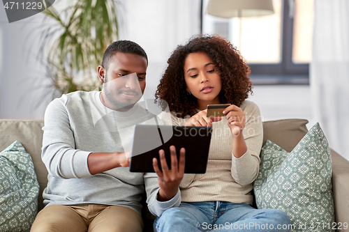 Image of couple with tablet pc and credit card at home