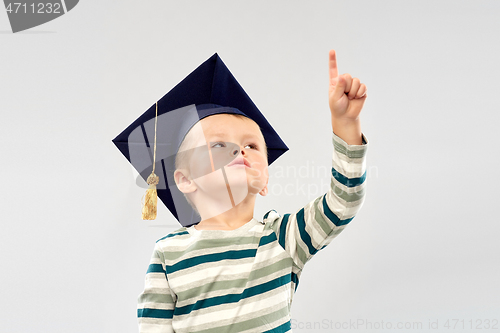 Image of little boy in mortar board pointing finger up