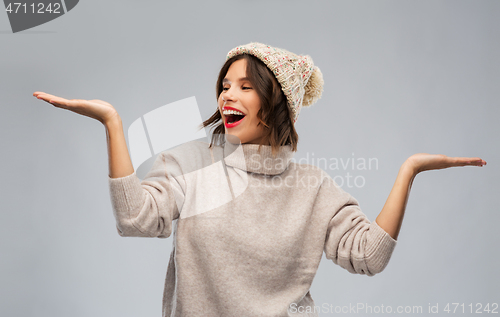 Image of young woman in winter hat holding something