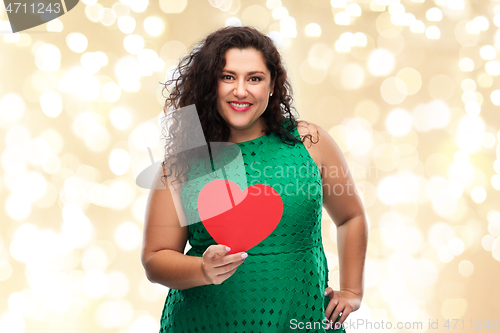 Image of happy woman holding red heart over lights