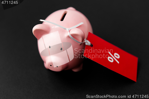 Image of piggy bank with red sale tag on black