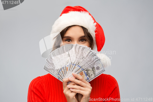 Image of happy woman in santa hat with money on christmas