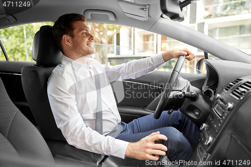 Image of smiling man or driver driving car