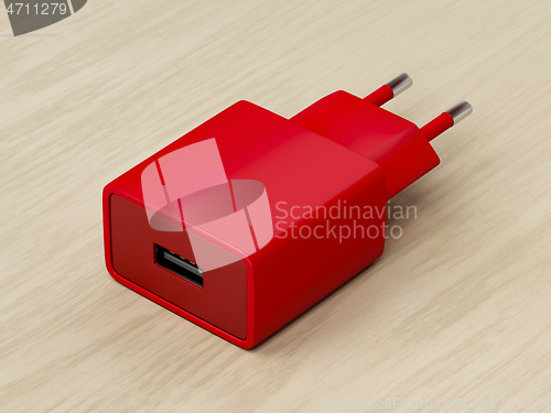 Image of Red power adapter on wood background