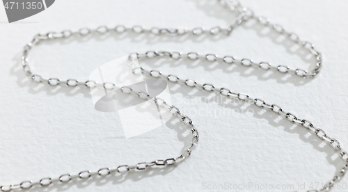 Image of silver chain on white paper background