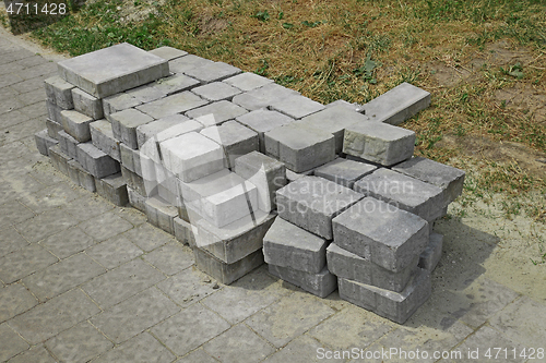 Image of Pile of gray paving slabs stacked on the roadside