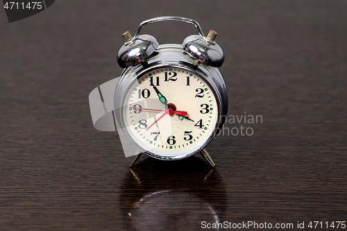 Image of Metal alarm clock on a wooden table