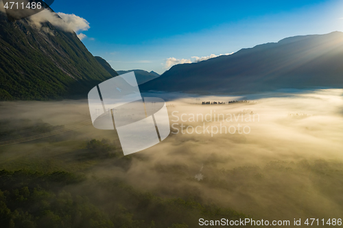 Image of Morning mist over the valley among the mountains in the sunlight