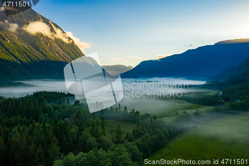 Image of Morning mist over the valley among the mountains in the sunlight