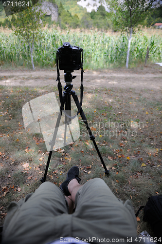 Image of pov photographer in nature taking timelapse photo on pro dslr ca