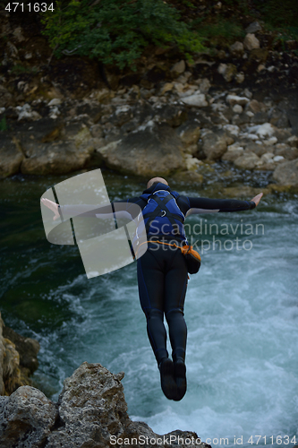 Image of Man jumping in wild river