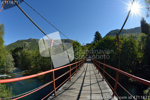 Image of wooden bridge over wild river