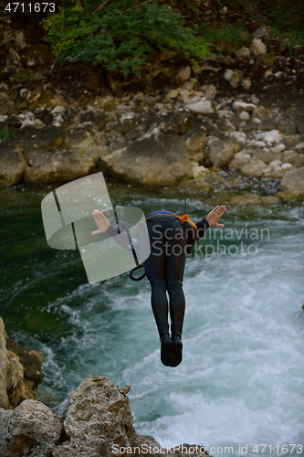 Image of Man jumping in wild river