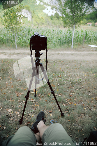 Image of pov photographer in nature taking timelapse photo on pro dslr ca