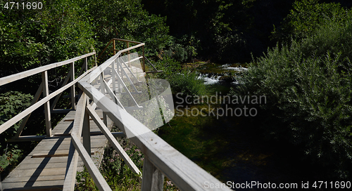 Image of wooden bridge over wild river