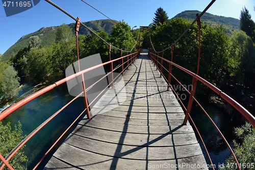 Image of wooden bridge over wild river