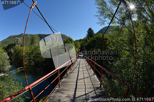 Image of wooden bridge over wild river