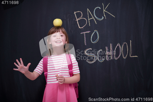 Image of child holding apple on head