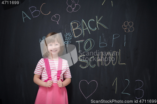 Image of school girl child with backpack writing  chalkboard