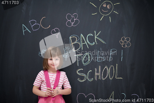 Image of school girl child with backpack writing  chalkboard