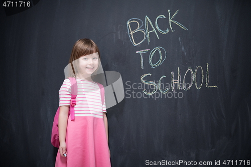 Image of school girl child with backpack writing  chalkboard