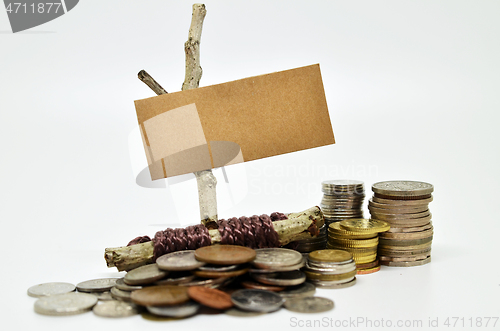 Image of Paper sign board with stack of coins