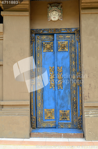 Image of Traditional blue painted front doors of a house in Bali
