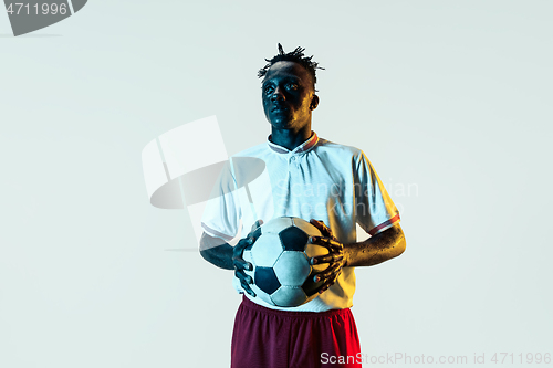 Image of Male soccer player standing with the ball isolated on white background