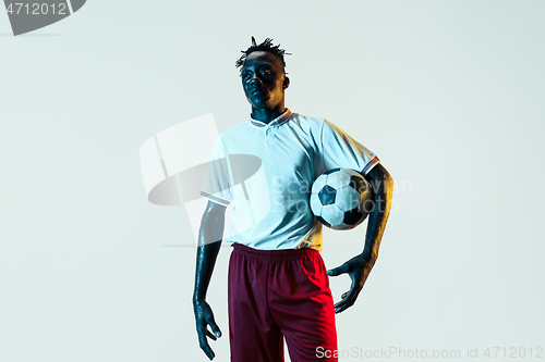 Image of Male soccer player standing with the ball isolated on white background