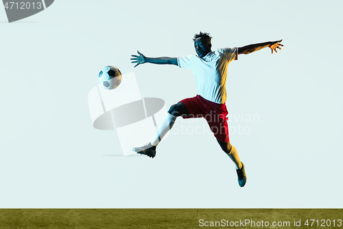 Image of Male soccer player kicking ball isolated on white background