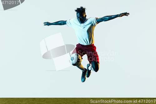 Image of Male soccer player kicking ball isolated on white background