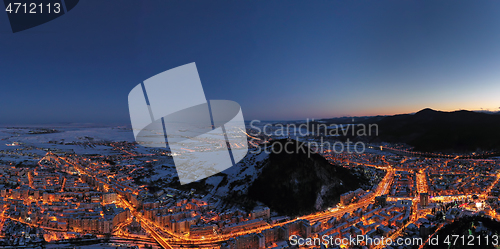 Image of Aerial view after sunset, city lights and mountains