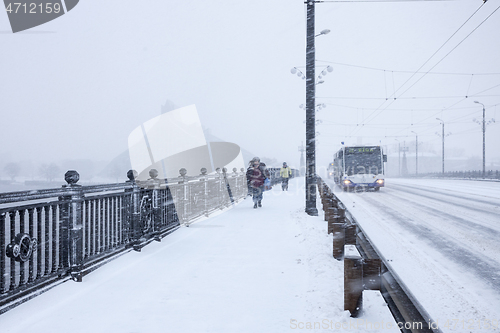 Image of Pedestrians and Bus during heavy snow storm