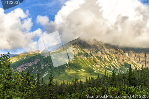 Image of Polish Tatra mountains summer landscape with blue sky and white clouds.