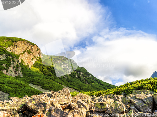 Image of Polish Tatra mountains summer landscape with blue sky and white clouds.