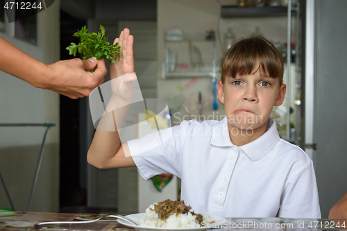 Image of The girl refuses fresh greens for lunch