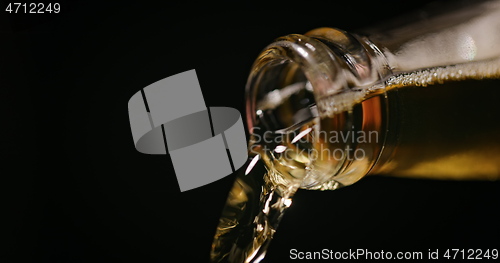 Image of Beer being poured against dark background with slow movements