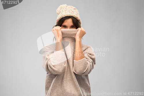 Image of young woman in knitted winter sweater and hat