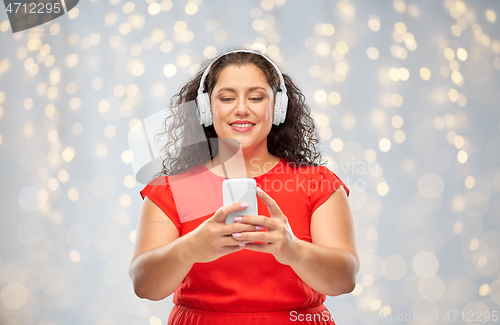 Image of woman in headphones listens to music on smartphone