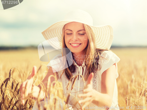 Image of happy young woman in sun hat on cereal field