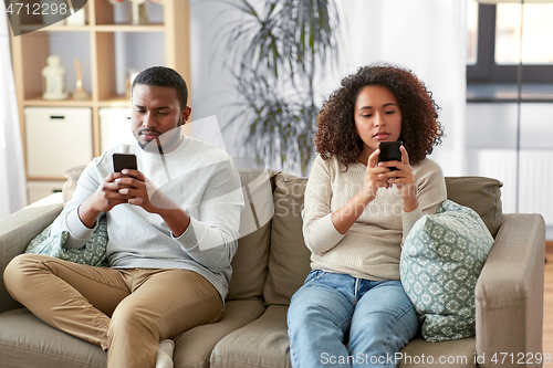 Image of african american couple with smartphone at home