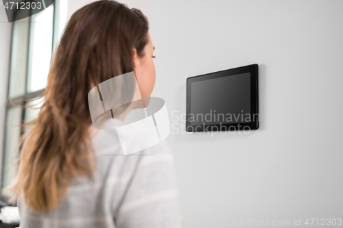 Image of woman looking at tablet computer at smart home