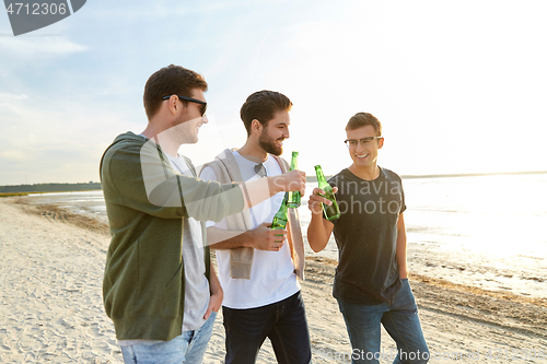 Image of young men toasting non alcoholic beer on beach