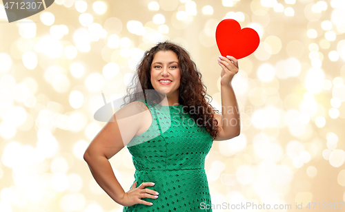Image of happy woman holding red heart over lights