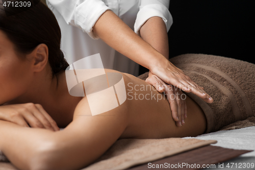 Image of woman lying and having back massage at spa