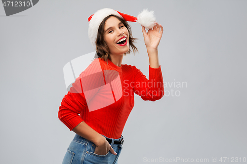 Image of happy young woman in santa hat on christmas