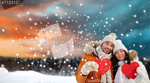 Image of happy couple with red hearts over winter landscape